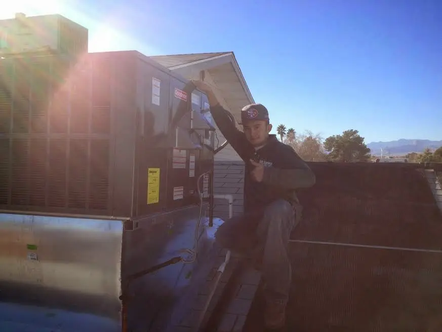 HVAC technician performing AC Tune-Up on a rooftop unit in Upper Dublin